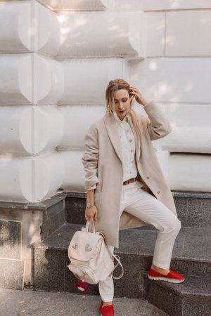 Fashion woman wearing beige trendy coat walking on the streetの写真素材