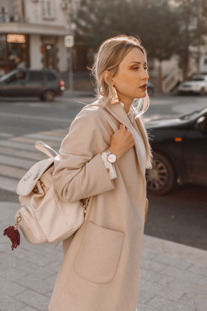Fashion woman wearing beige trendy coat walking on the streetの写真素材