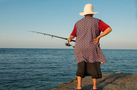 The elderly woman catches fish. Taken on Crete, Greece - October 2012.の写真素材