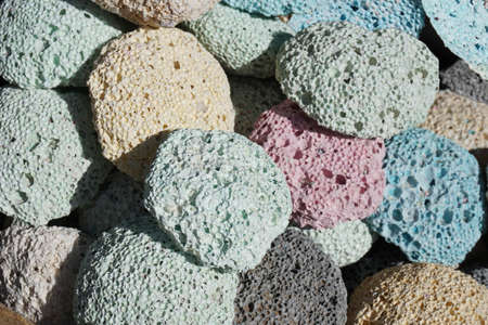 Many multicolored porous pumice stones are next to each other.の写真素材