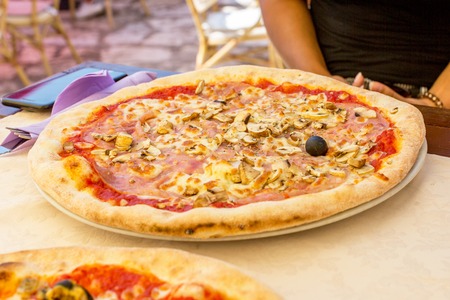 Pizza with mushrooms and ham in a restaurant