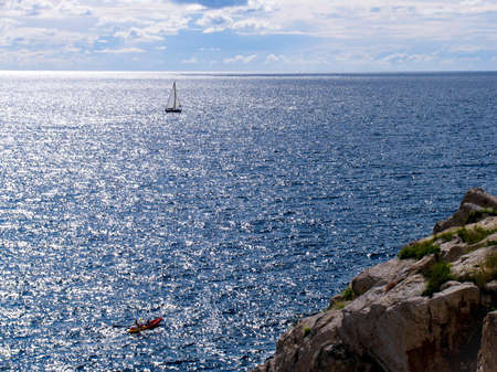 Amazing view of lonely yacht at open sea. Top view from cliffの写真素材