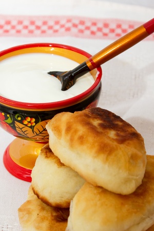 Fried pies with cabbage and sour cream colored saucerの写真素材