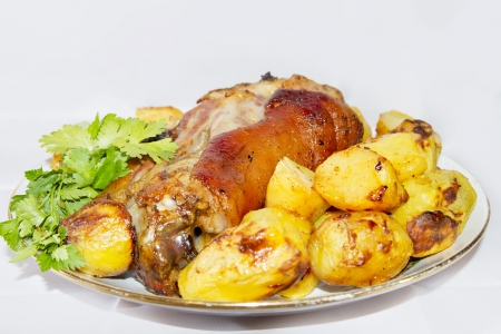 Baked pork shank with potatoes and parsleyの写真素材