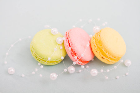 French multicolored macaroon cookies entwined with pearl beadsの写真素材