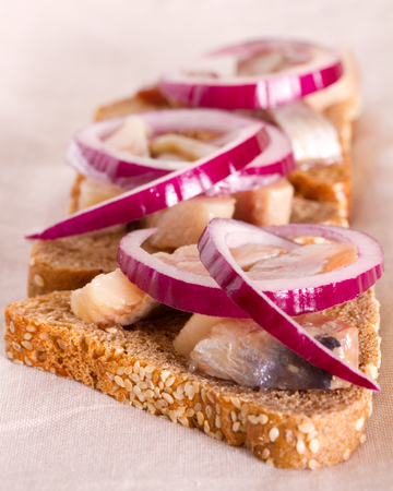 Fisherman Sandwich with rye bread, herring and red onionの写真素材