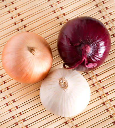 Three large onions of different colorsの写真素材