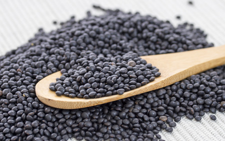 Wooden spoon with black lentilsの写真素材