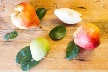Whole and slice of ripe pears and green pear on a blackboardの写真素材