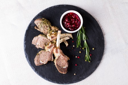 Rack of lamb with cranberry sauce on a stone platterの写真素材
