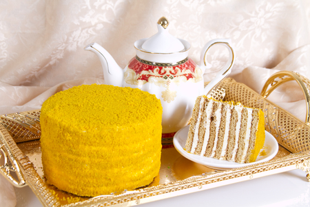 Fruit honey cake and teapot with green teaの写真素材