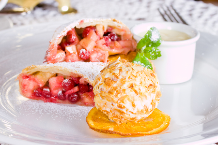 Apple strudel and ice cream ball with cashew nutsの写真素材