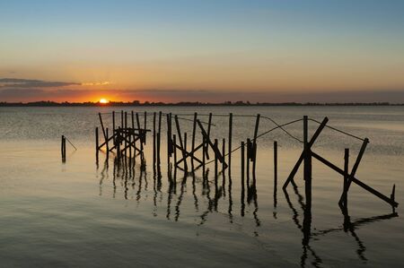 old pier under a reddish sunsetの写真素材