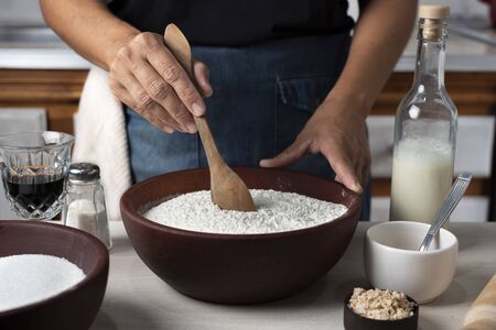 wooden spoon stirring flour