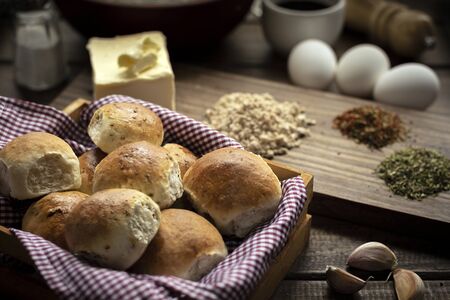 flavored homemade breads on basket basket with ingredients on wooden table backgroundの写真素材