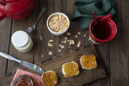 cup of tea with cereals and toast with jam breakfast snack