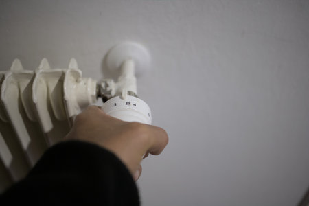 Hand on the house heating temperature controller for energy savingの写真素材