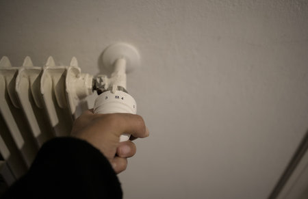 Hand on the house heating temperature controller for energy savingの写真素材