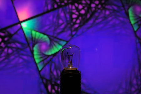 Vintage light bulb on the background of the colorful spider web.の写真素材