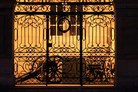 Bicycle parked in front of a window with a wrought iron latticeの写真素材