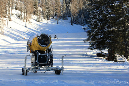Snow cannon on the ski slope in the winter forest, Italy.の写真素材