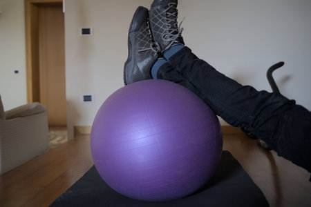 Close-up of woman's legs with pilates ball at homeの写真素材