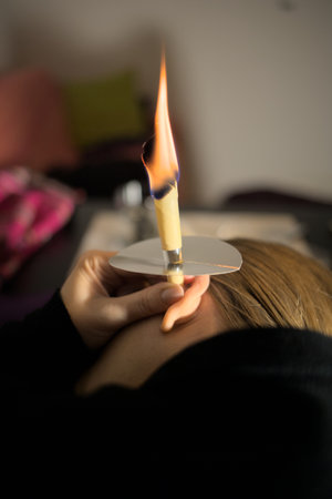 Woman holding ear cone for cleaning ear wax out of ear plugsの写真素材