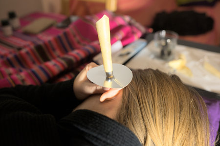 Woman with ear wax problems-removing ear wax plug with wax cones take care at homeの写真素材