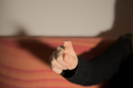 Hand of a young woman in a black sweater pointing a finger at the cameraの写真素材