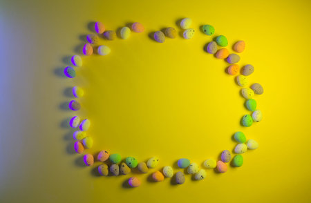 Colorful easter eggs on a yellow background with copy space.の写真素材