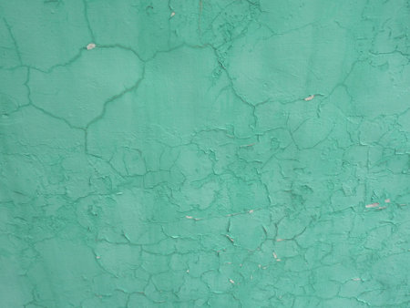 Cracked green paint on the wall. Abstract background and texture.