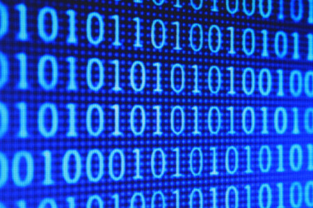 Binary code on a computer screen close-up. Blue background