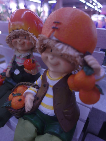 Cute little boy and girl doll with tangerines and orangesの写真素材
