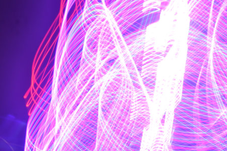 Abstract background of moving light lines on a dark background. Long exposure photo.