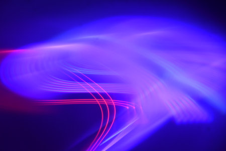 abstract background of the colorful blurred rays of light on a dark background