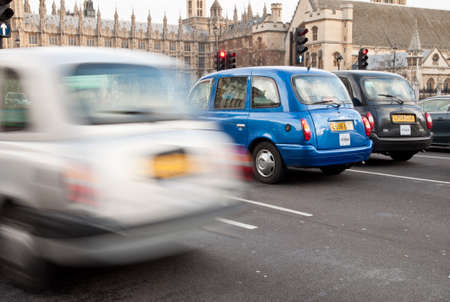 London, UK - February 17, 2012: Tipycal London taxis waiting by the traffic light in front of Westminsterのeditorial素材