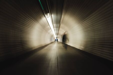 Businesswoman crossing a tunnel in London. Image with blur zoom effectの写真素材