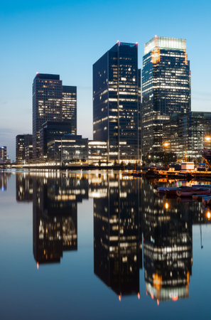 Reflections of corporate buildings in water, Canary Wharf, Londonの写真素材