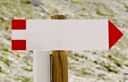 Blank wooden arrowed-shaped direction signpost in the mountains