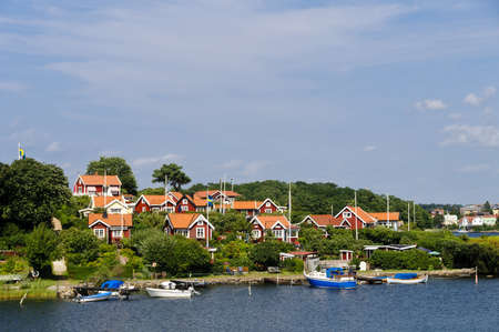 Swedish cottages on the sea painted in the typical  Falun red  color in Brändaholm, Karlskrona county, Swedenの写真素材