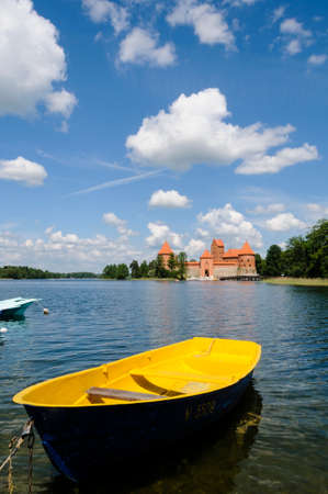 A yellow boat with the castle of Trakai in the background Lithianiaのeditorial素材