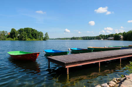 Colorful rowing boats moored on a wooden pier on Lake Galve in Trakai, Lithuania, Europeの写真素材