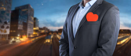 Businessman with heart on city backgroundの写真素材