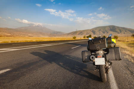 Beauty motobike on lanscape long road and field with mountの写真素材