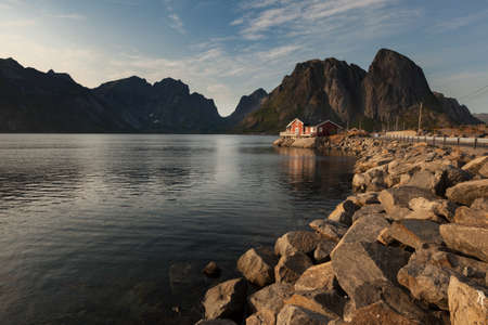 Beautiful litle house in a lake or in a large river with mount backgroundの写真素材