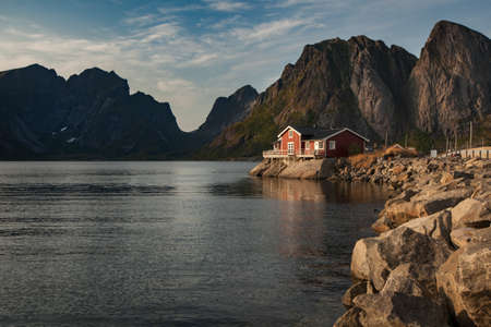 Beautiful litle house in a lake or in a large river with mount backgroundの写真素材
