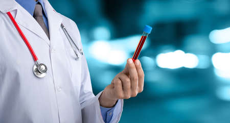 Doctor man in a white coat with a stethoscope on an abstract blur bokeh backgroundの写真素材