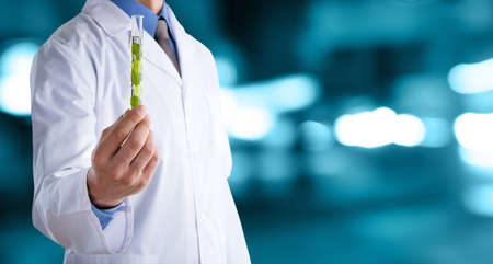Doctor man in a white coat with a stethoscope on an abstract blur bokeh backgroundの写真素材