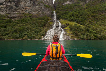 Little kayak in a lake or in a big river with a beautiful girl traveler on natural backgroundの写真素材