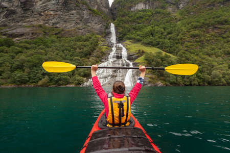 Little kayak in a lake or in a big river with a beautiful girl traveler on natural backgroundの写真素材